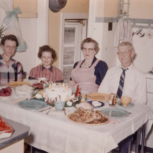 a group of people sitting around a table with food on it